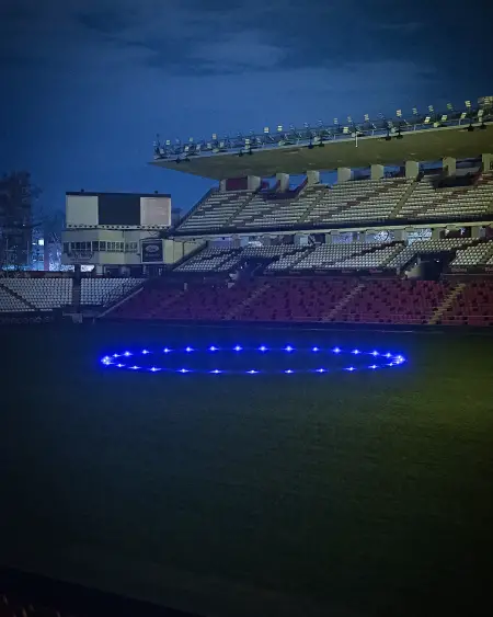 Imagen del césped del Estadio de Vallecas iluminado en honor a la Policía Nacional